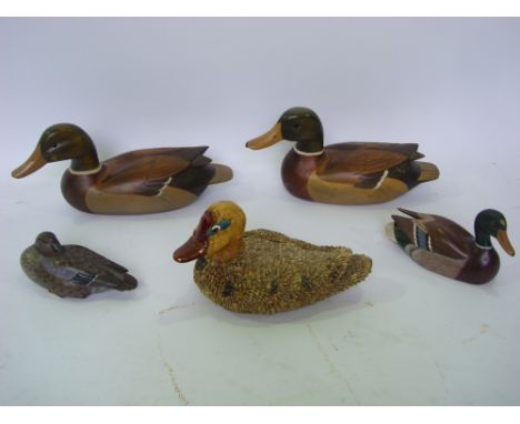 Four painted and carved wood decoy style duck ornaments and another ceramic example covered in seeds (5). 