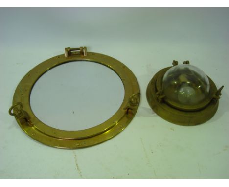 A brass ships port hole wall mirror and a round cast brass ships bulkhead light (2). 