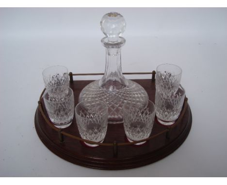 A crystal ships decanter and six matching tumblers on a brass galleried rosewood stand. 
