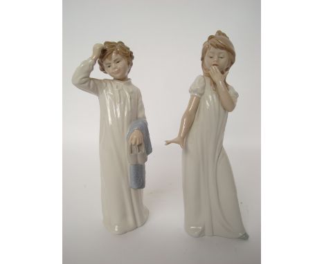 Two Nao figurines of children in night shirts. 