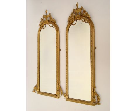 A pair of late Victorian gilt gesso arched rectangular pier glasses, with ovolo and beaded moulded border, the crest surmount