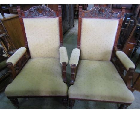 A pair of late Victorian drawing room chairs with upholstered seat, backs and arm pads within moulded and carved show wood fr