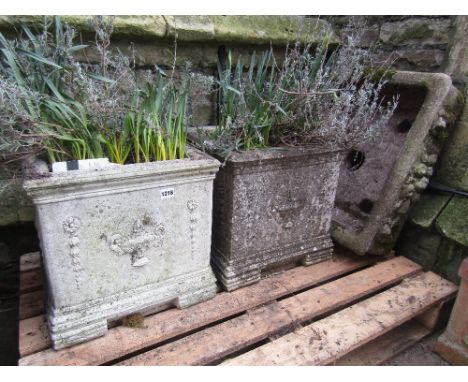 A pair of contemporary weathered cast composition stone garden planters of square form with raised relief classical urn and t