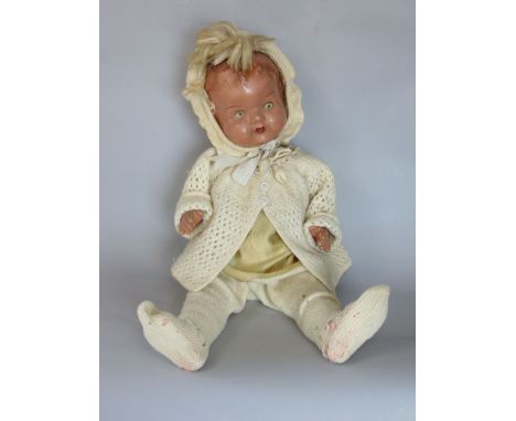 A vintage plaster headed doll with clothes