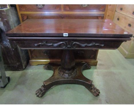 A Victorian rosewood veneered fold over top card table of rectangular form with baize lining raised on a vase shaped pillar w