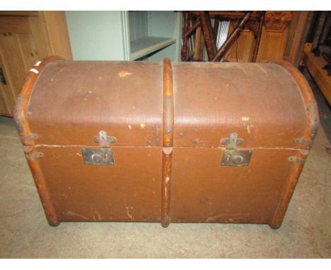 A vintage brown fibre and timber lathe bound dome top travelling trunk, with stitched leather side carrying handles