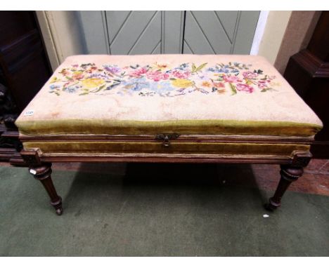 A Victorian centre stool of rectangular form with rising lid, hand worked tapestry top with walnut framework and raised on fo