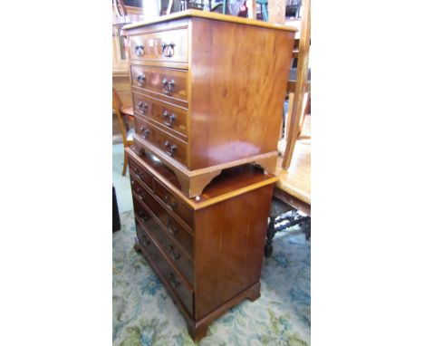 A reproduction Georgian style yew wood veneered bedroom chest of three long and two short graduated drawers raised on shaped 