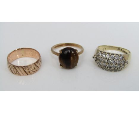 Three 9ct rings including a claw set tigers eye example and an engraved wedding ring, K/L, N & K, 9g total
