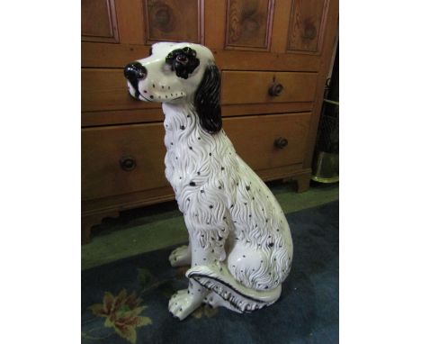 A ceramic spotted hound in seated pose, 64 cm in height