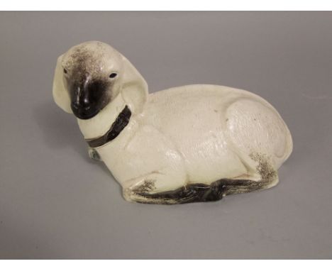 A ceramic model of a recumbent goat with cream and brown glazed finish and with moulded mark to interior London Pottery, 25 c