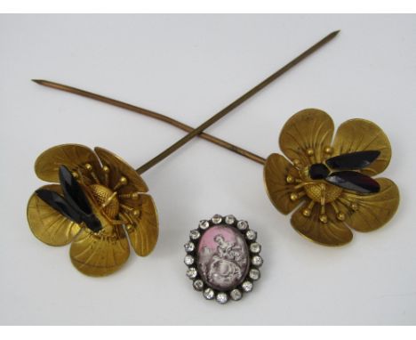 A pair of gilt metal wig pins in the form of buttercups with applied bees, the wings set with red Vauxhall glass, together wi