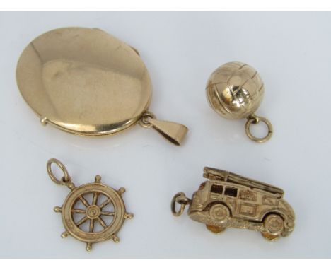 A 14ct locket together with three 9ct charms including a double hinged example in the form of a fire engine, 11g total (4)
