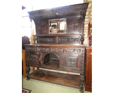 A substantial Victorian oak buffet in an old English style with carved detail, the lower section enclosed by an arrangement o