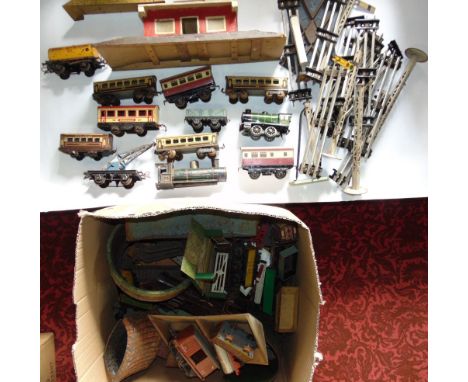 A box containing a collection of vintage tin plate railwayana to include track, houses, carriages, etc