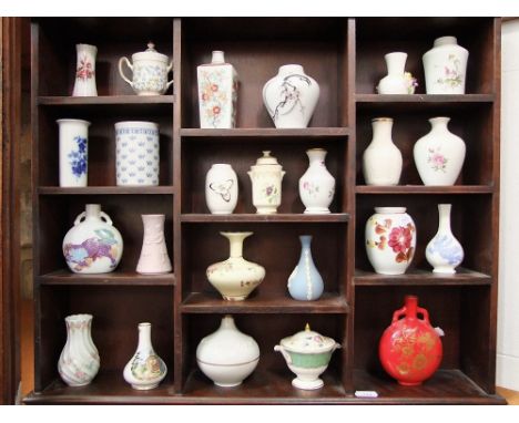 A sectional wooden display shelf containing a quantity of miniature vases by Wedgwood, Coalport, Lladro, etc