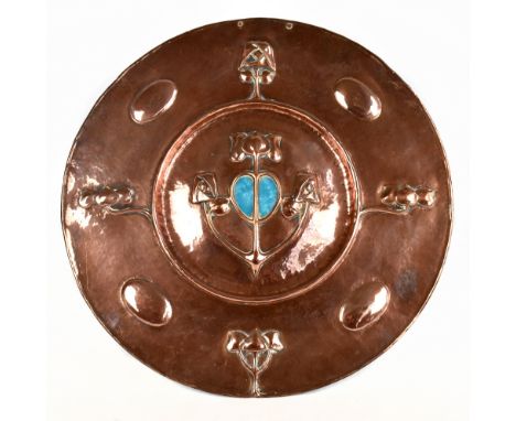 IN THE MANNER OF W.J. NEATBY; an Arts &amp; Crafts copper wall charger circa 1900 embossed with stylised detail and central p