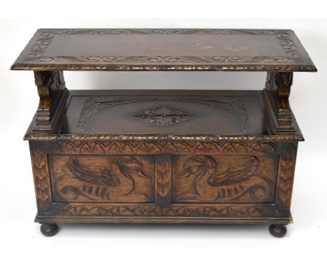 A 1920’s carved oak monk's bench, with hinged box base and turned feet, height 75cm, width 106cm, depth 45cm.&nbsp;Additional