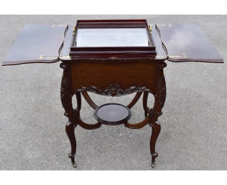 A Victorian mahogany serpentine drinks table, the hinged cover enclose a rising glass tray, on carved cabriole legs, height 7