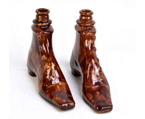 A pair of 19th century treacle glazed flasks modelled as lady's boots with buttons to the side and vacant aperture above, unm