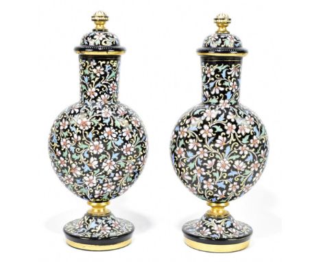 A pair of late 19th century Bohemian enamelled black glass vases and covers, decorated throughout with scrolling floral detai