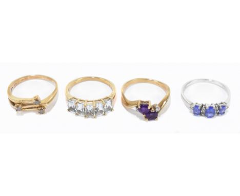 Three 9ct gold dress rings, one set with five emerald cut pale blue stones, gross weight 9.5g, and a white metal dress ring s