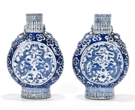 A pair of late 19th century Chinese blue and white moon flasks, each decorated with four claw dragons, surrounded by prunus f