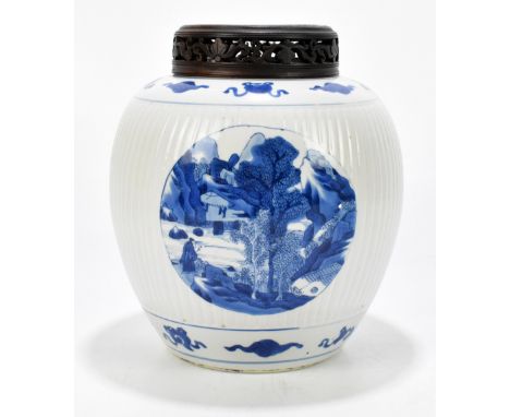 A Kangxi period Chinese blue and white porcelain vase with ribbed linear detail, the three circular panels painted with figur