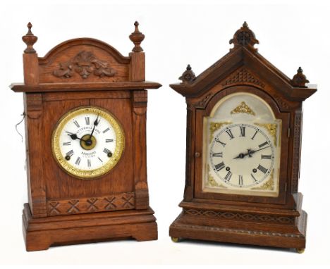 LENZKIRCH; a late 19th century oak cased mantel clock with carved detail to the front flanking the silvered face set with Rom