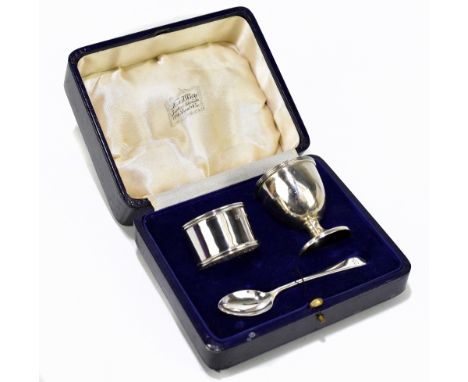 A hallmarked silver three piece christening set comprising egg cup, napkin ring, and spoon, the egg cup and napkin ring Birmi