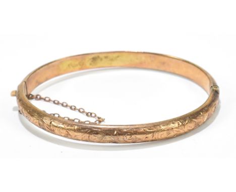 A 9ct yellow gold snap bangle with chased decoration to the front band, approx 8.5g.Additional InformationDenting, minor knoc