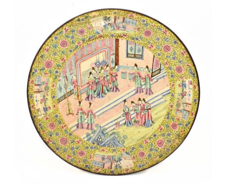 A 19th century Chinese enamel charger decorated with figures inside floral detail and four panels with figures in a landscape
