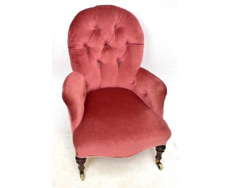 A Victorian nursing chair, with button back pink upholstery, on turned stained wood legs, height 80cm.