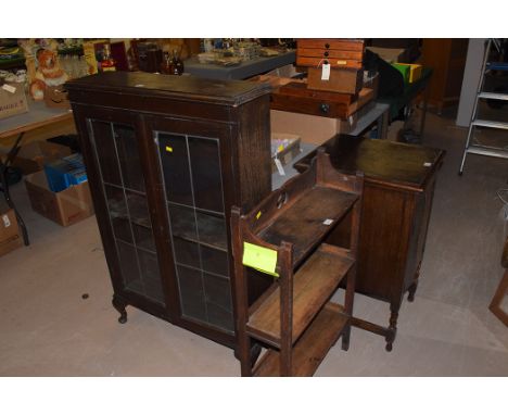 A mid 20th century stained oak bookcase with lead glazed panelled doors, 77cms wide; an oak Art Nouveau book shelf; and a mid