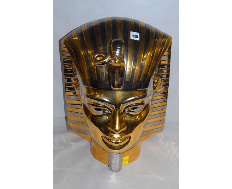 A ceramic head of a Pharaoh in gold and silver coloured decoration. 