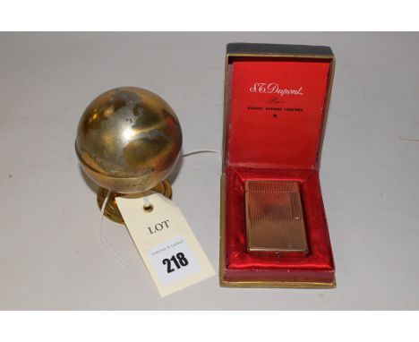 A table lighter in the form of a metal terrestrial globe, containing a table lighter with inscription; and another pocket cig