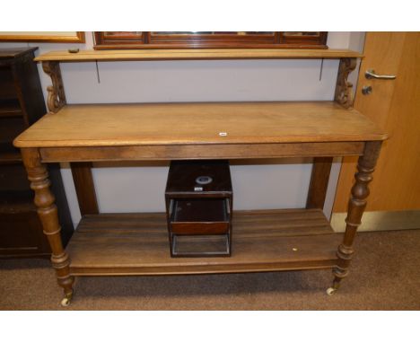 A Victorian oak buffet, raised on ceramic castors, 144cms wide; and a stained wood desk top filing tray.  (2)