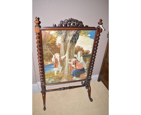 A Victorian rosewood firescreen raised on barley-twist supports, enclosing woolwork tapestry of children at play, 76cms wide.