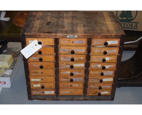 A watchmakers cabinet containing a selection of tools and parts.