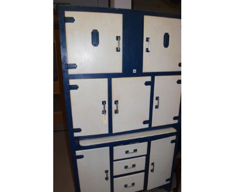 An early 20th Century white and blue painted kitchen unit, with pull-out enamel work surface, fitted an arrangement of seven 