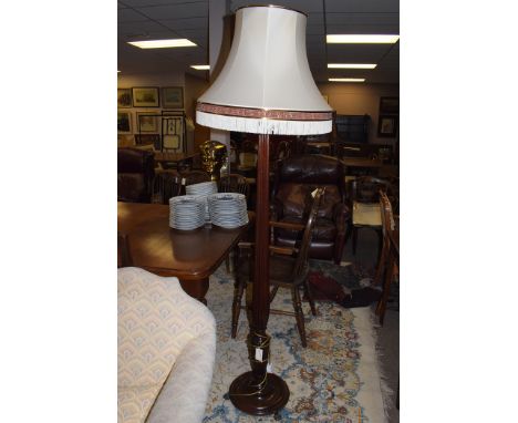 A 20th Century mahogany standard lamp, with cream and burgundy shade.