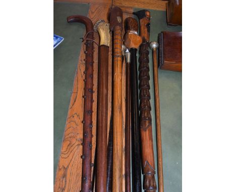 An RAF leather-bound swagger stick with white metal mount; two other swagger sticks; carved walking sticks, one in the form o