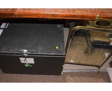 A grey painted metal trunk with key; brass fire screen with bevelled and engraved glass panel. (2)