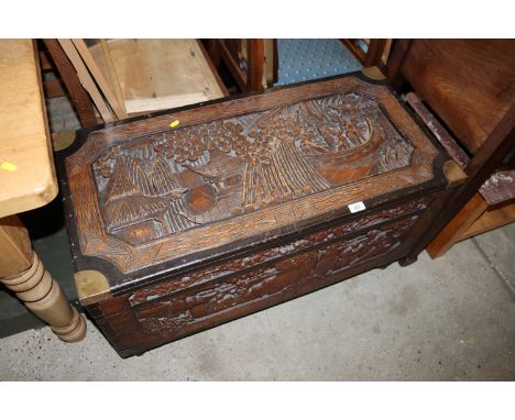 A brass mounted carved camphor wood trunk