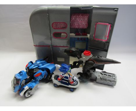 Four assorted plastic toys including Go Girl caravan, Sonic The Hedgehog, Transformer style robot and dinosaur