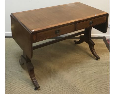 An Edwardian mahogany sofa table in the George III style, the cross-banded satinwood and rosewood strung top over two frieze 