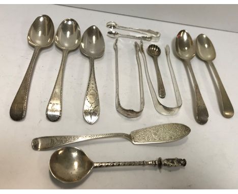 A collection of various silver flatware including two pairs of Georgian sugar tongs, five dessert spoons, apostle spoon, butt