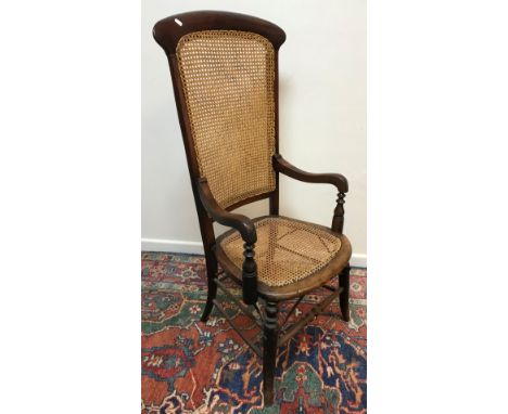 A Victorian cane back and seated mahogany framed elbow chair on turned legs united by stretchers 56 cm wide x 126.5 cm high, 