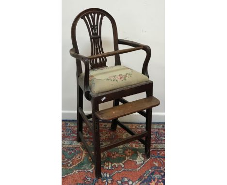 A 19th Century Hepplewhite design mahogany framed child's highchair with pierced back splat and shaped open arms over a tapes