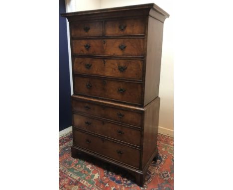 An 18th Century walnut and cross banded chest on chest, the upper section with swept cornice over two short and three long gr